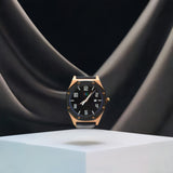 An elegant rose gold and black watch suspended mid-air above a reflective cube, creating a striking visual with a sense of weightlessness and sophistication