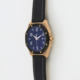 Angled view of the LUQ Rose Gold Watch showing its brushed rose gold case, bold navy blue dial, and premium leather strap. A perfect combination of style and performance.